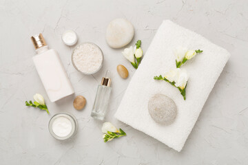 Flat lay with spa products and flowers on concrete background