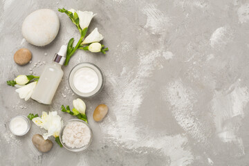 Flat lay with spa products and flowers on concrete background