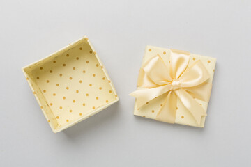 Beige open gift box on color background, top view