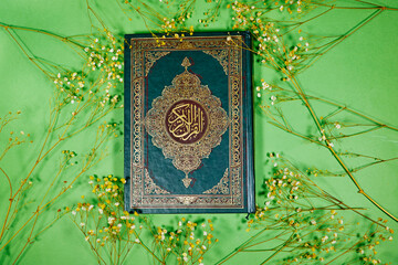 muslim book with Arabic calligraphy Quran translation :  holy book of Muslims with gypsophila...
