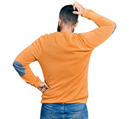 Hispanic man with beard wearing casual winter sweater backwards thinking about doubt with hand on head