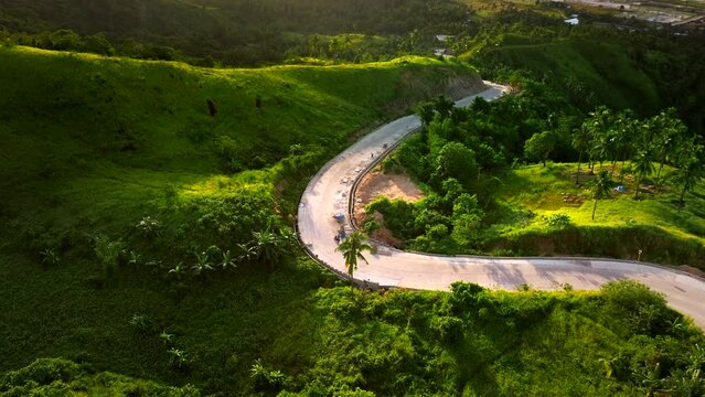 Aerial view of a person with a motorbike on a scenic road on the hills in San Vicente Viewpoint, Palawan, Philippines.