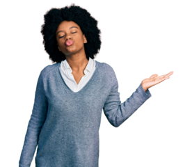 Young african american woman presenting with open palm looking at the camera blowing a kiss being lovely and sexy. love expression.