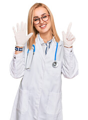 Beautiful caucasian woman wearing doctor uniform and stethoscope showing and pointing up with...