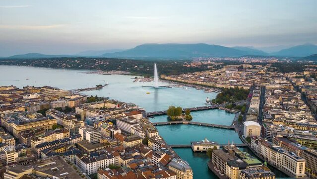 Geneva, Switzerland skyline view towards the Jet d'Eau fountain in Lake Geneva at dusk.