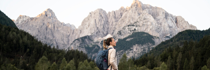 Profile view of a young female hiker looking at a beautiful view of high mountains