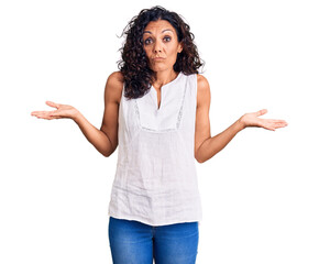 Middle age beautiful woman wearing casual sleeveless t shirt clueless and confused expression with...