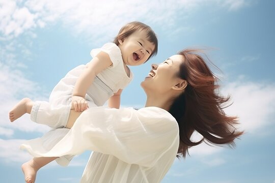 A happy mother is holding her baby up in the air