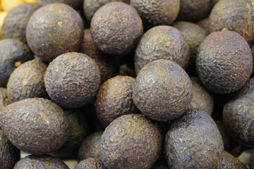 closseup brown and black avocados are stacked on top of each other, nature, fruit,food, health, copy space