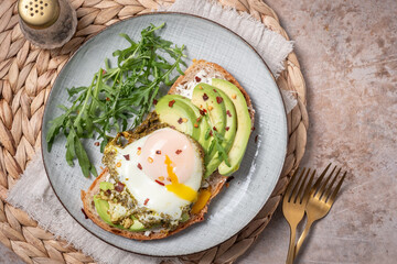Avocado egg sandwich. Healthy light breakfast concept. Whole grain toasts with avocado and fried pesto eggs