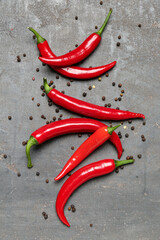 Fresh chili peppers with peppercorns on dark background