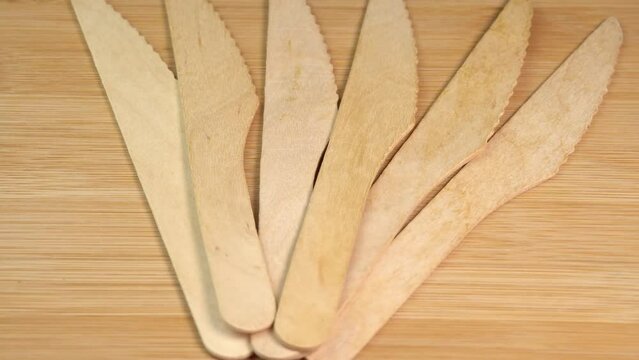 Row of wooden knives on cutting board surface. Wooden