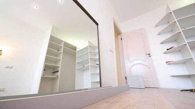 Empty room with slide door wardrobe under assembling, shelves