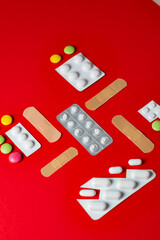 collection colorful pills, multiple blister packs and bandages on stark red background, representing variety of medical treatments
