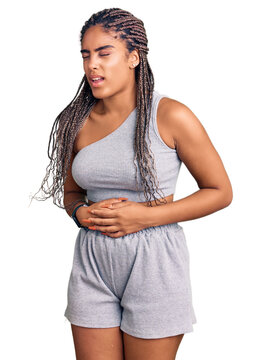 Young african american woman with braids wearing sportswear with hand on stomach because nausea, painful disease feeling unwell. ache concept.