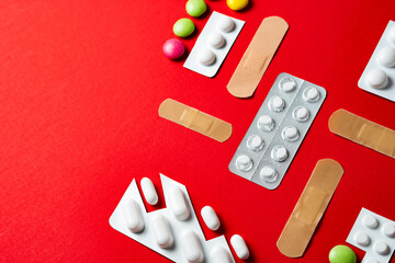 Healthcare and First Aid Concept with Medication and Bandages on vivid red background, copy space