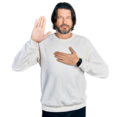 Middle age caucasian man wearing casual clothes swearing with hand on chest and open palm, making a...