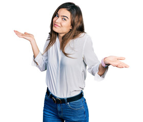 Young caucasian girl wearing casual white shirt clueless and confused expression with arms and...