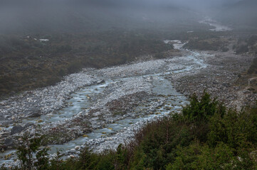 View of Bhote Koshi river in the fog in Thame during Three passes trekking in Himlayas, Khumbu region, Nepal, Asia. Long exposure photography.