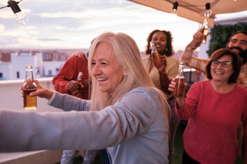 Close-up of senior woman dancing and having fun with a group of friends. Concept: party, together
