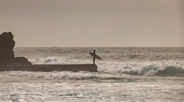 Surfero observando el mar antes de entrar a surfear olas en un mar furioso