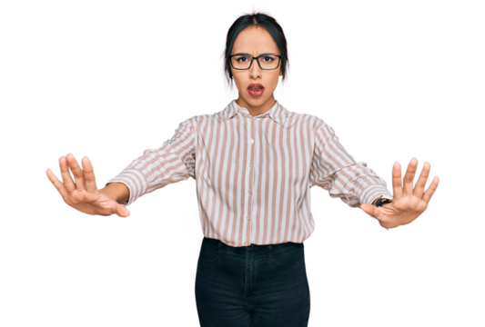 Young hispanic girl wearing casual clothes and glasses doing stop gesture with hands palms, angry and frustration expression