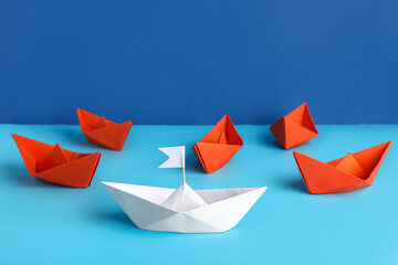 Colorful origami boats on color background