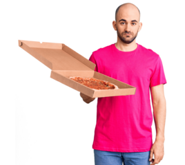 Young handsome man holding delivery pizza cardboard box thinking attitude and sober expression looking self confident
