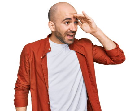 Young hispanic man wearing casual clothes very happy and smiling looking far away with hand over head. searching concept.