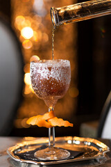 Captivating image of a deluxe cocktail, adorned with ice and burnt rosemary, set against a festive and romantically lit backdrop. Ideal for holiday-themed projects