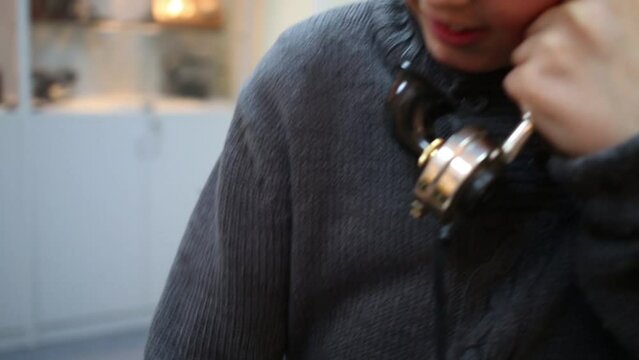 Boy in grey talks old phone in Museum of phone in Preobrazhenskoe