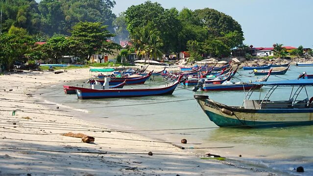 Fishing boats on the sea and beach of George Town city in the distance on the Strait of Malacca in Penang, Malaysia. 
