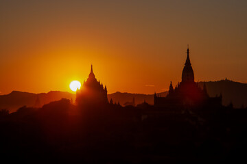the dreamlike sunset in front of the shilouttes of the pagodas in bagan 
