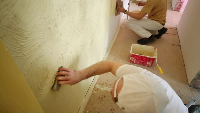 Two professional builders making finish in the apartment.
