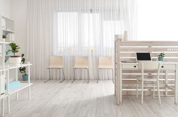 Interior of modern clinic with reception desk and chairs