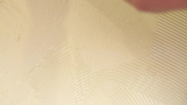 Close-up view of making finish abstract wall in yellow room.