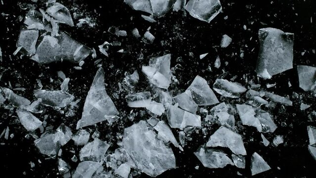 Super Slow Motion Shot of Falling Piece of Ice on Black Stone Background at 1000 fps.