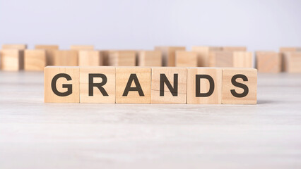 wooden cubes with letters GRANDS on a gray table