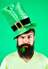 Bearded man in green top hat with clover in mouth. Saint Patrick's day celebration. National Irish...