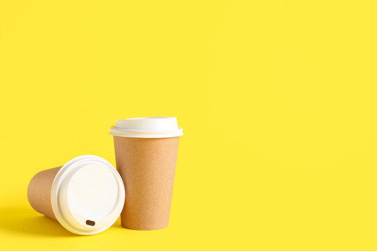 Takeaway paper cups on yellow background