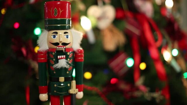 Toy Nutcracker and illuminated garland of Christmas tree