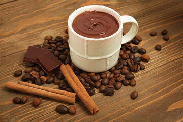 Cup of tasty melted chocolate, coffee beans and cinnamon on white background, closeup