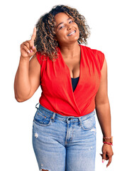 Young african american plus size woman wearing casual style with sleeveless shirt pointing finger up with successful idea. exited and happy. number one.
