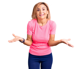 Young blonde woman wearing sportswear smiling cheerful offering hands giving assistance and acceptance.