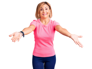 Young blonde woman wearing sportswear looking at the camera smiling with open arms for hug. cheerful expression embracing happiness.