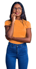 Young indian girl wearing casual clothes and glasses looking stressed and nervous with hands on mouth biting nails. anxiety problem.