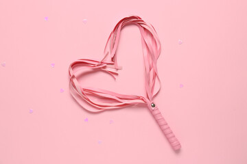 Heart made of whip from sex shop on pink background