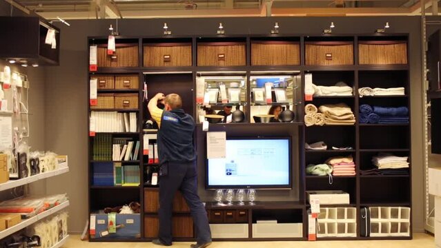 Worker makes hole by drill in modern shop of furniture. 