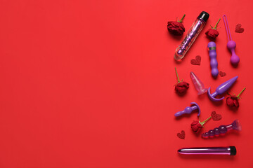 Composition with beautiful rose flowers and different sex toys on red background - obrazy, fototapety, plakaty