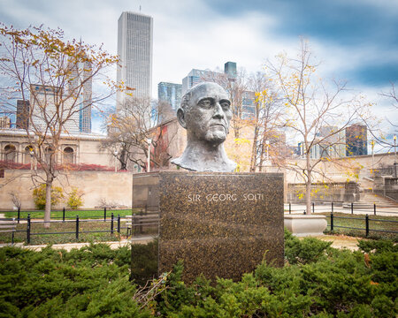Grant Park, Chicago, Illinois - USA: Sir Georg Solti Bust in the Sir Georg Solti Garden with Chicago skyscrapers in background. Late autumn, dramatic sky.